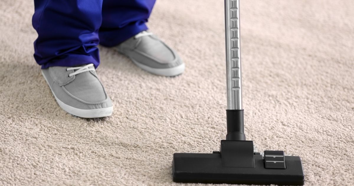 Cleaner Cleaning the Carpet with Vacuum Cleaner