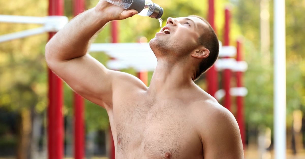 Sporty Young Man Drinking Water Outdoors