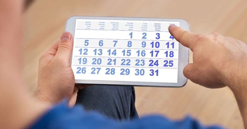 man looking at calendar waiting for four weeks to fully grow his beard