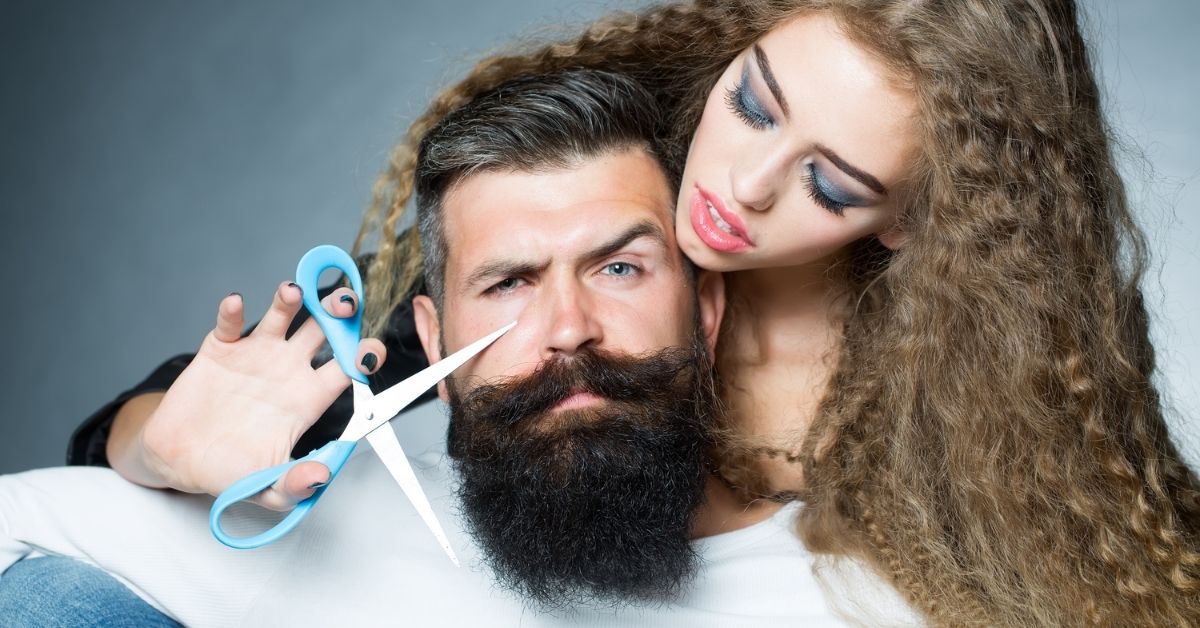 Woman holding a scissor and want to cut the man's beard because not all women like beards