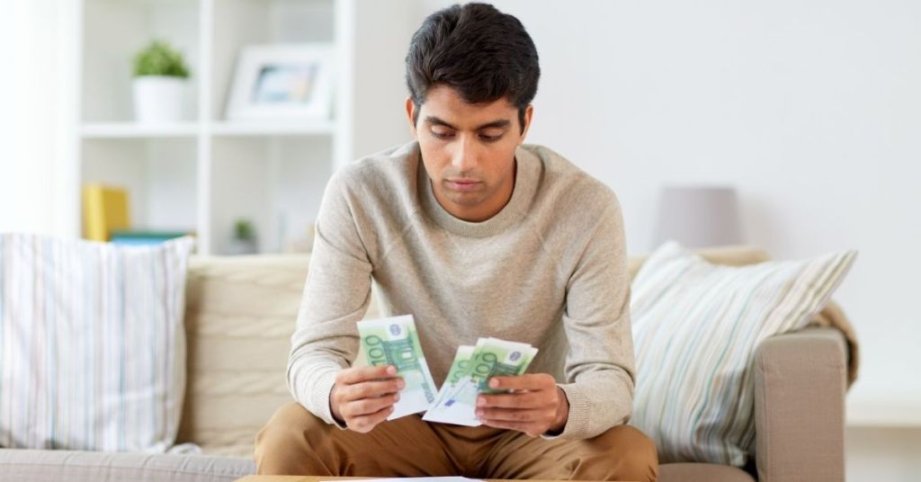 Man counting money to set budget