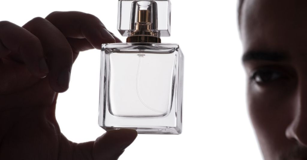 Man holding a bottle of cologne