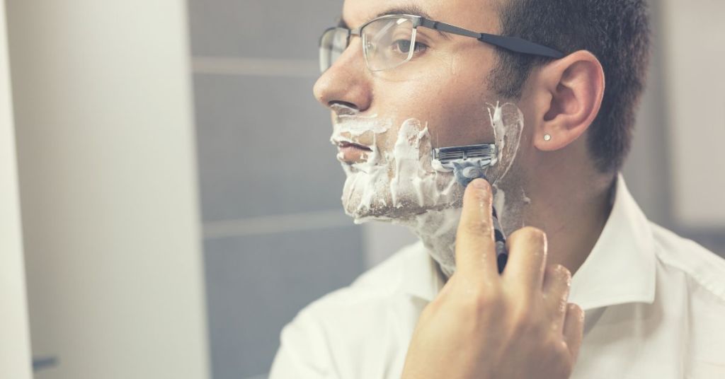 man shaving using sharp razor