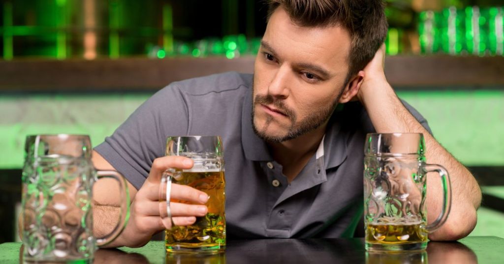 Man drinking beer alone at the bar