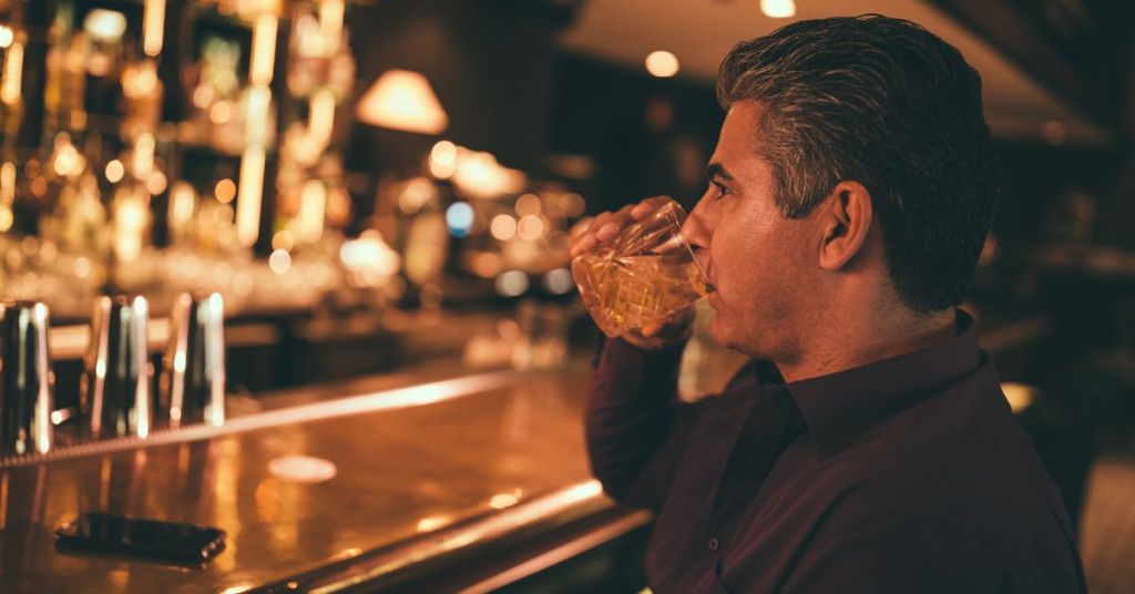Man drinking neat bourbon
